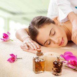 Masseur doing massage on woman body in the spa salon. Beauty treatment concept.